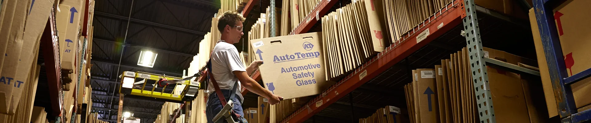 Auto Temp employee pulling boxed glass from warehouse shelving