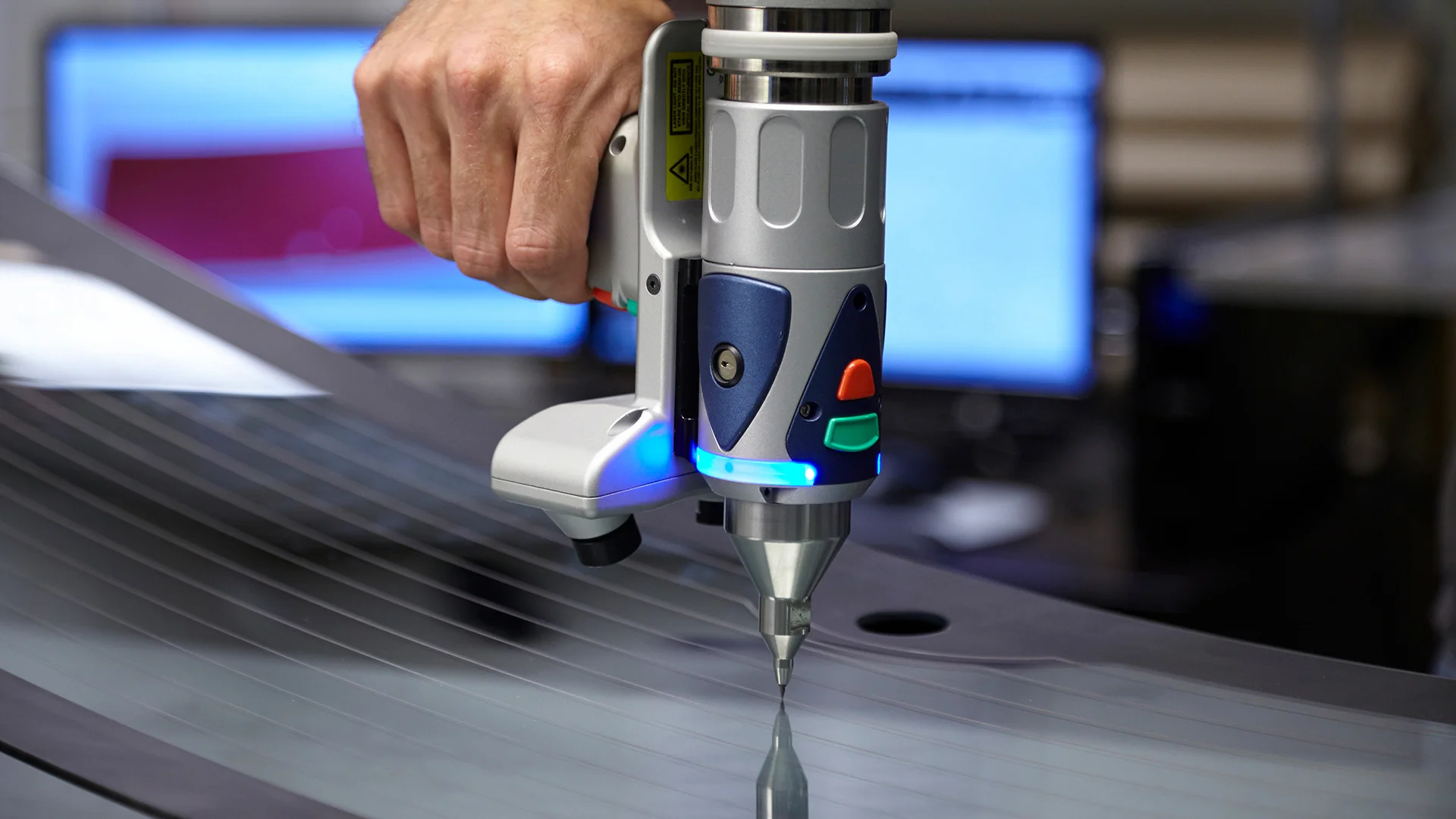 Engineer measuring a glass part with a portable 3D scanning arm