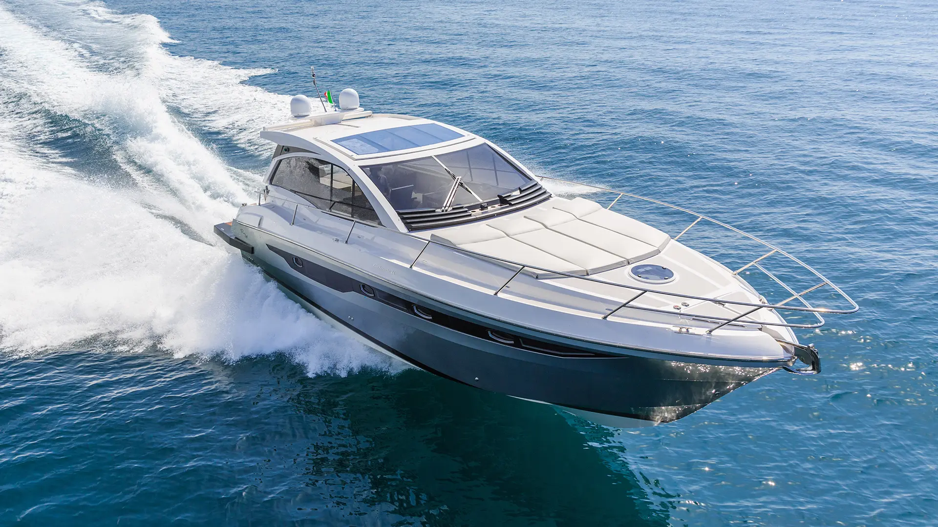 Motor yacht with a tempered glass windshield cruising on open water